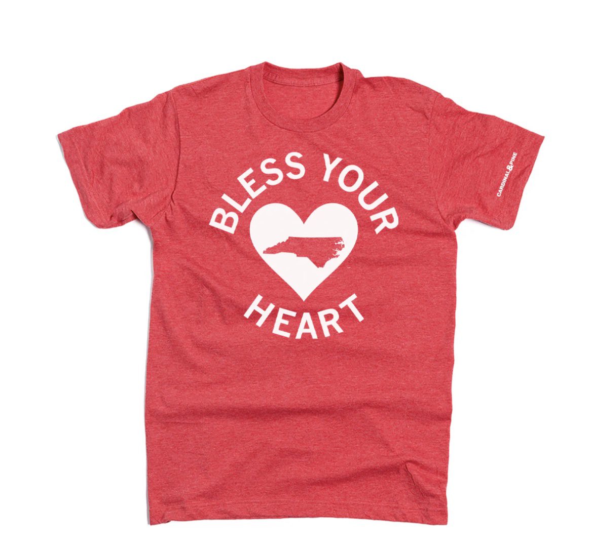 A red Cardinal & Pine t-shirt that reads "Bless Your Heart"
